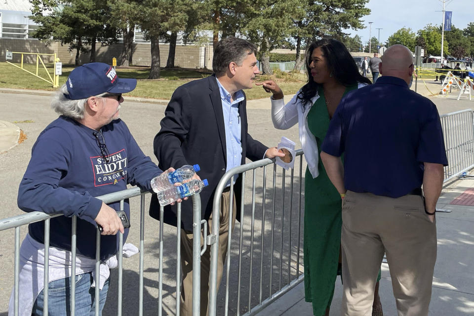 Kristina Karamo, the Republican nominee for Michigan's secretary of state, stops to talk with prominent election denier and former state Sen. Patrick Colbeck outside a rally for President Donald Trump in Warren, Mich., Saturday, Oct. 1, 2022. Colbeck attended the rally with MyPillow chief executive Mike Lindell. (AP Photo/Joey Cappelletti)