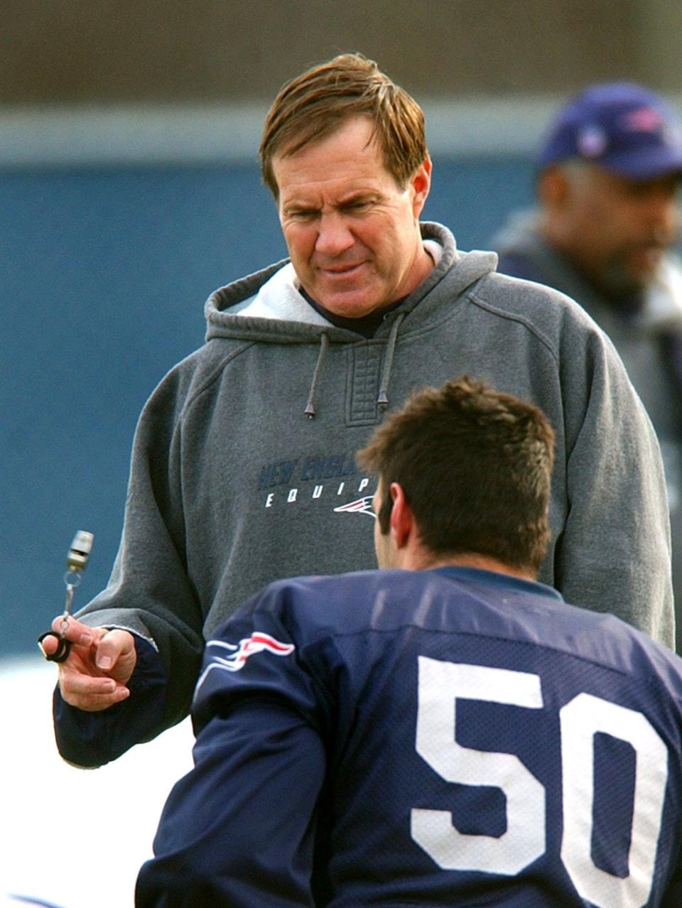 New England Patriots coach Bill Belichick spins his whistle while talking with linebacker Mike Vrabel (50) during a practice Dec. 23, 2003, in Foxboro, Mass.