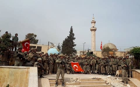 Turkish soldiers stand in crescent form in Afrin town centre - Credit: Anadolu Agency/Getty Images