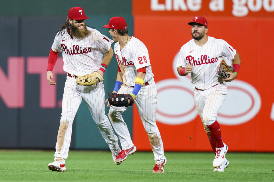 Philadelphia Phillies' Nick Maton, center, celebrates the win with Brandon Marsh, left, and Kyle Schwarber, right, following the ninth inning of a baseball game against the Washington Nationals, Saturday, Sept. 10, 2022, in Philadelphia. The Phillies won 8-5. (AP Photo/Chris Szagola)