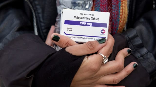 A person holds a box of mifepristone pills