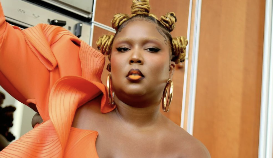Lizzo poses in bold orange lipstick and bleached eyebrows. (Instagram)