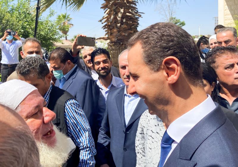 Syria's President Bashar al-Assad greets a supporter after casting his vote, during the country's presidential elections in Douma