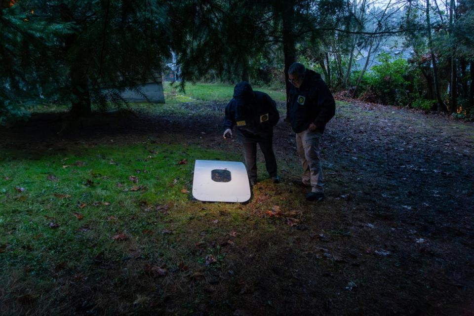 This handout image released by the National Transportation Safety Board (NTSB) shows agents inspecting the door plug from Alaska Airlines Flight 1282 on 8 January 2024 after being found in Portland, Oregon. (National Transportation Safety B)