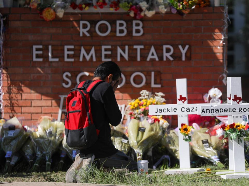 A man prays in front of a makeshift memorial outside Robb Elementary School in Uvalde, Texas, on May 25, 2022.