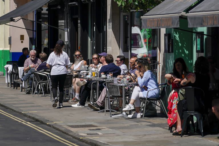 Personas disfrutan un día soleado en un restaurante de Soho, Londres. 