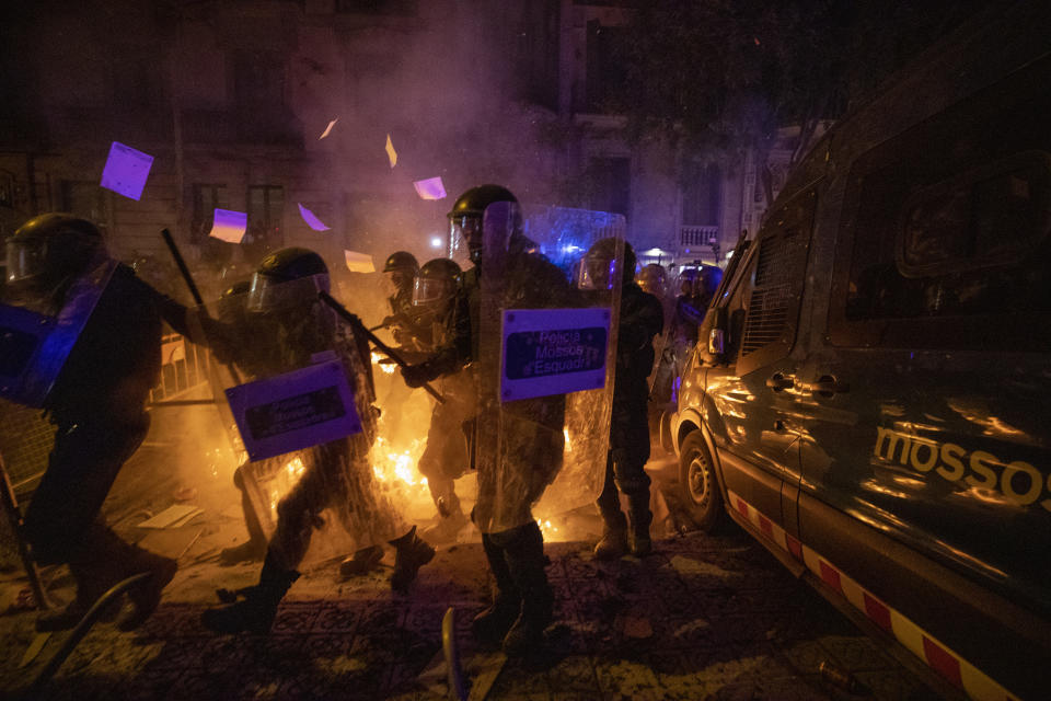 Policemen in riot gear move past a burning barricade during clashes with protestors in Barcelona, Spain, Tuesday, Oct. 15, 2019. (Photo: Emilio Morenatti/AP)