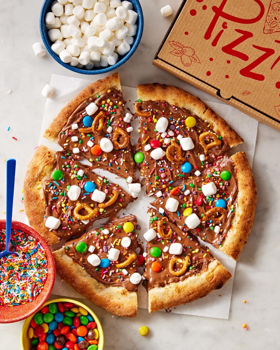 chocolate covered pizza dough topped with marshmallows, pretzels, and candy