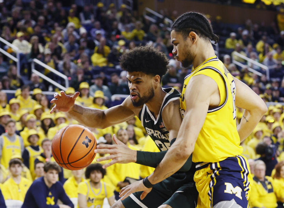 Michigan State forward Malik Hall (25) loses control of the ball next to Michigan forward Olivier Nkamhoua (13) during the first half of an NCAA college basketball game Saturday, Feb. 17, 2024, in Ann Arbor, Mich. (AP Photo/Duane Burleson)
