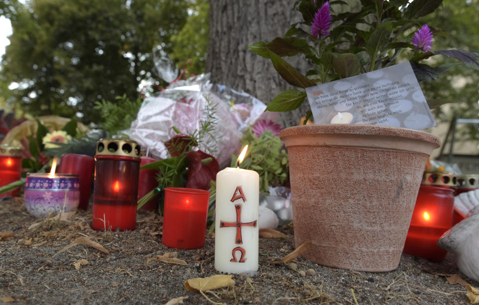 Candles burn at the site of a deadly brawl in Koethen, 90 miles southwest of the German capital Berlin, Sunday, Sept. 9, 2018. Police has arrested two Afghan men on suspicion of murder in the killing of a 22-year-old German man. (AP Photo/Jens Meyer)