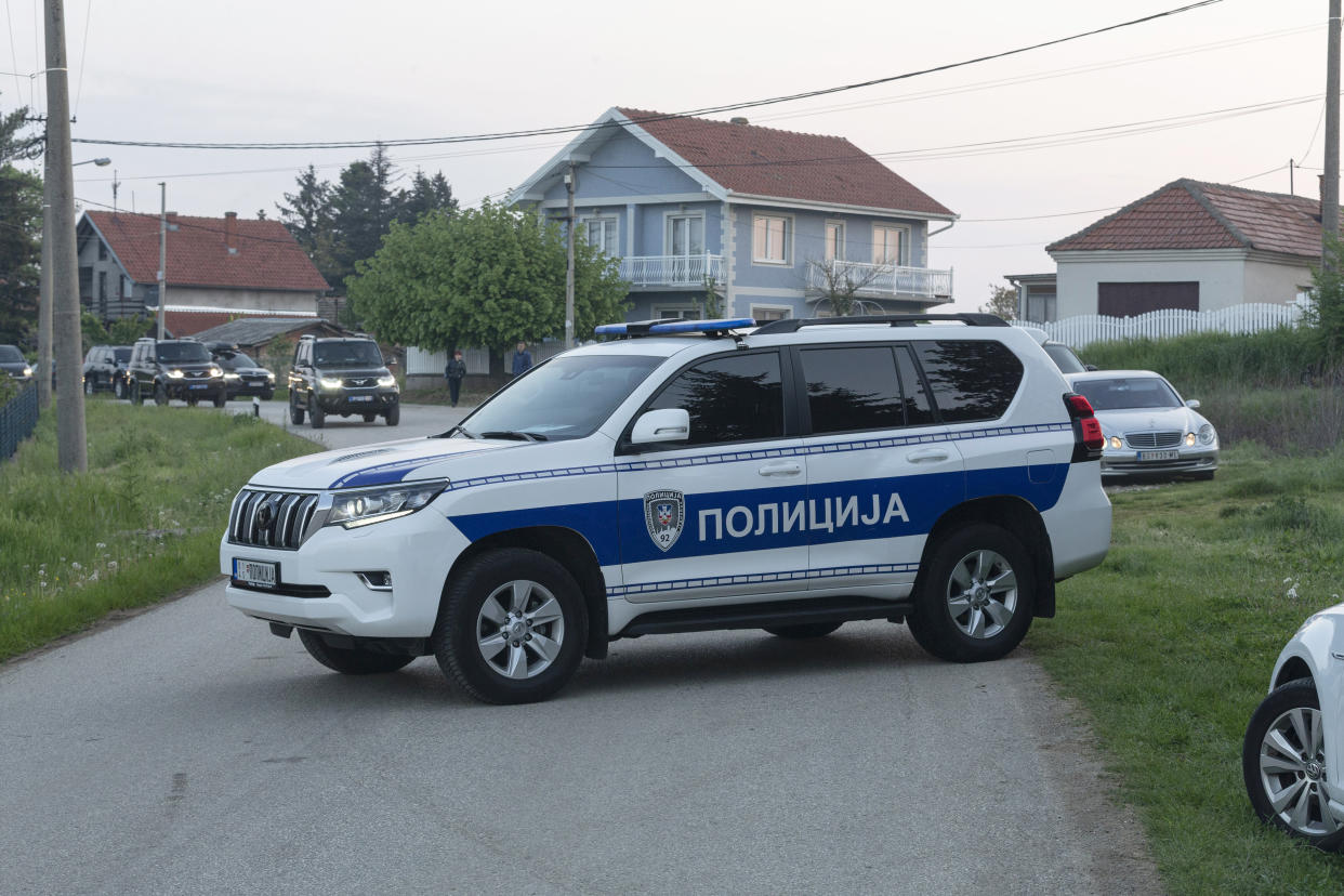 A police vehicle blocks the entrance to the village of Dubona, some 40 kilometers south of Belgrade, Serbia, Friday, May 5, 2023. A shooter killed multiple people and wounded more in a drive-by attack late Thursday in Serbia's second such mass killing in two days, state television reported. (AP Photo/Marko Drobnjakovic)