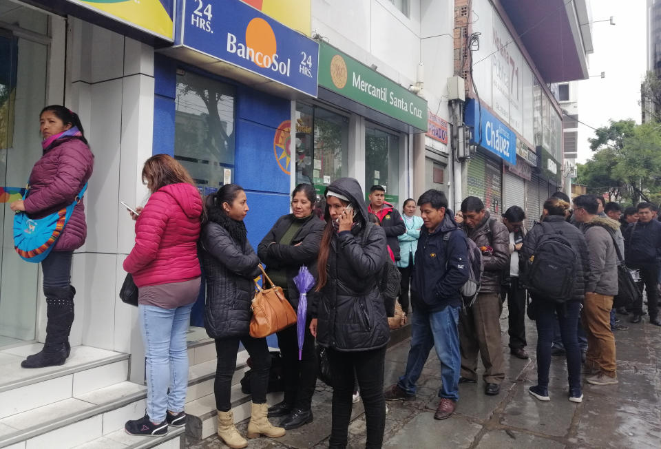 People line up to use cash machines, amid protests in La Paz, Bolivia, Monday, Nov. 11, 2019. The Nov. 10 resignation of President Evo Morales leaves a power vacuum and a country torn by protests against and for his government. ( (AP Photo/Paola Flores)