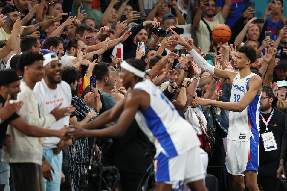 PARIS, FRANCE - AUGUST 08: Frank Ntilikina #1 and Victor Wembanyama #32 of Team France celebrate with fans after their team's win against Team Germany after a Men's basketball semifinals match between Team France and Team Germany on day thirteen of the Olympic Games Paris 2024 at Bercy Arena on August 08, 2024 in Paris, France. (Photo by Gregory Shamus/Getty Images)