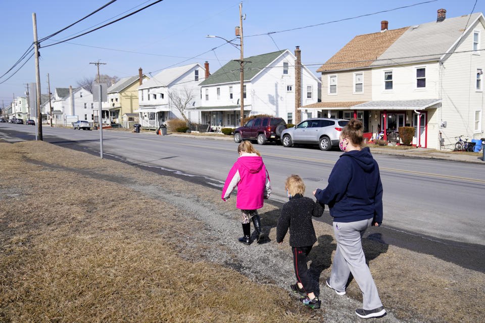 From right, Melissa Weirich, walks with her son, Julien Heim, 4, and daughter, Kacie Thompson, 9, to visit the former home of Kacie's friend, Ava Lerairo, Thursday, March 11, 2021, in Lansford, Pa. On May 26, 2020, Ava; her mother, Ashley Belson, and Ava's father, Marc Lerario were found fatally shot. (AP Photo/Matt Slocum)