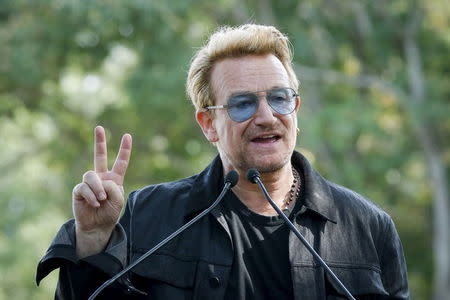 Irish singer Bono speaks to guests before the unveiling of a tapestry honoring John Lennon at Ellis Island in New York July 29, 2015. REUTERS/Eduardo Munoz