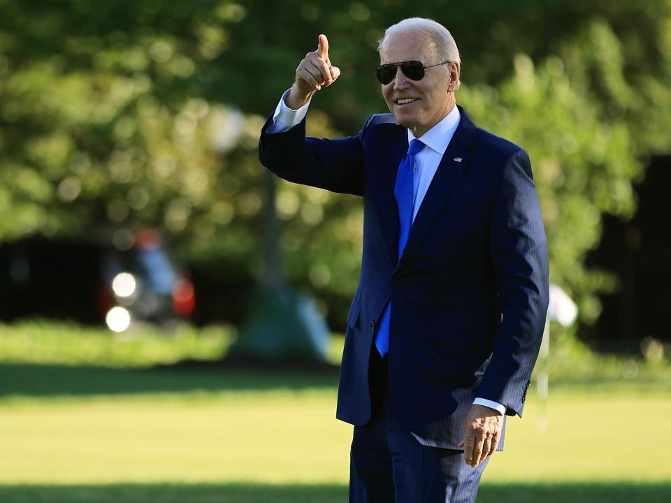 Joe Biden points to staff members from the South Lawn as he departs the White House on June 25, 2021