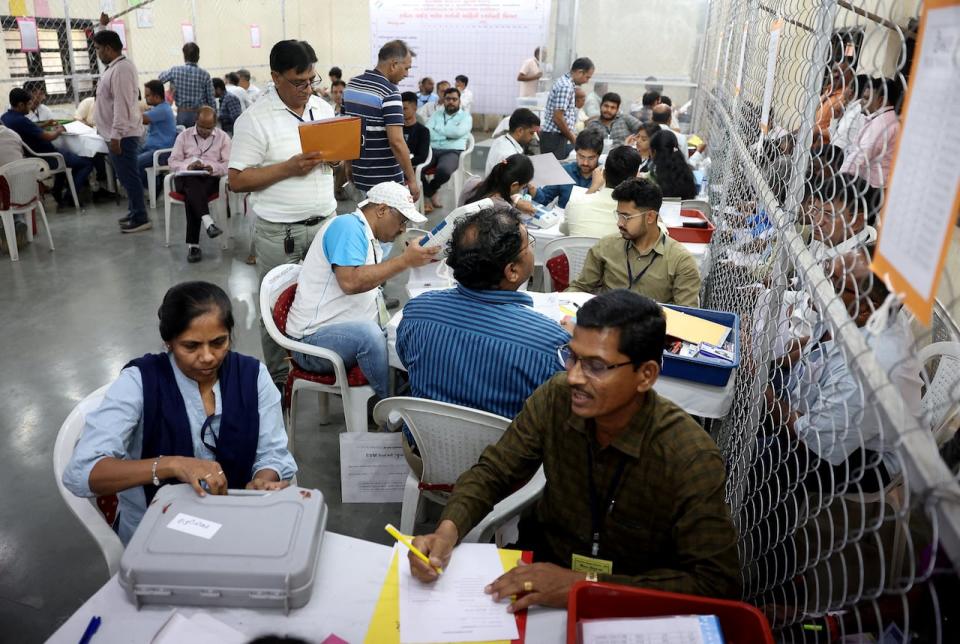 Election staff members open an electronic voting machine (EVM) to count votes for India's general election inside a vote counting centre in Ahmedabad, India, June 4, 2024. REUTERS/Amit Dave     TPX IMAGES OF THE DAY