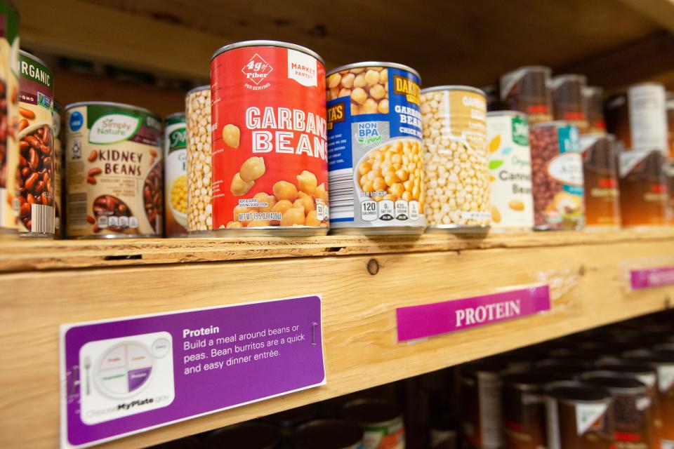 Cans of various types of beans are labeled with protein signage to help guide clients at Catholic Charities of Northeast Kansas to make informed decisions based on nutritional information.