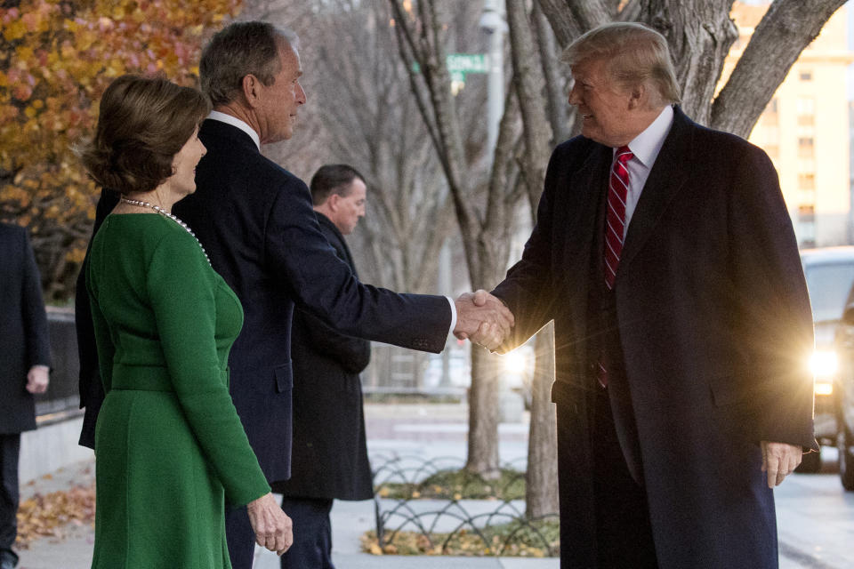 President Donald Trump, right, is greeted by former President George Bush and former first lady Laura Bush outside the Blair House across the street from the White House in Washington, Tuesday, Dec. 4, 2018. (AP Photo/Andrew Harnik)