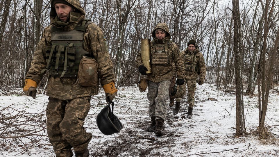 Ukrainian soldiers of the 57th Brigade walk with the remains of a powder charge in the direction of Kupiansk, in Ukraine's Kharkiv region, on November 27, 2023. - Diego Herrera Carcedo/Anadolu/Getty Images