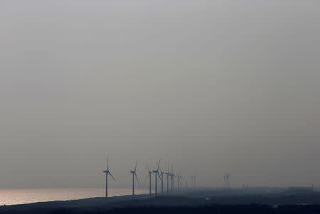 FILE PHOTO - Wind turbines at Chubu Electric Power Co.'s Omaezaki Wind Power Station are seen from the company's Hamaoka Nuclear Power Station in Omaezaki, Shizuoka Prefecture, May 17, 2013. REUTERS/Toru Hanai/File Photo