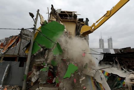 A bulldozers demolishes buildings at Kalijodo red-light district in Jakarta, Indonesia, February 29, 2016. REUTERS/Beawiharta