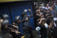 Residents of Pavao Pavaozinho slum clash with riot police during a protest against the death of Douglas Rafael da Silva Pereira, after his burial in Rio de Janeiro, Brazil, Thursday, April 24, 2014. The protest followed the burial of Pereira, whose shooting death sparked clashes Tuesday night between police and residents of the Pavao-Pavaozinho slum. (AP Photo/Felipe Dana)