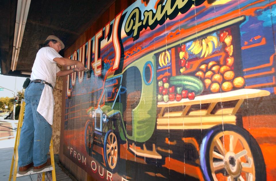 Stockton muralist Carlos Lopez applies a clear anti-ultraviolet/anti-graffiti coating over a 8'x16' mural he painted for the new Louie's Fruit and Produce store on Country Club Blvd. and Pershing Avenue in Stockton on Sept. 4, 2001.