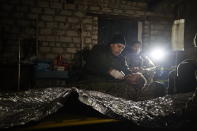 Ukrainian servicemen give the first aid to a soldier wounded in a battle with the Russian troops in their shelter in the Donetsk region, Ukraine, Thursday, Dec. 1, 2022. A top adviser to Ukraine's president has cited military chiefs as saying 10,000 to 13,000 Ukrainian soldiers have been killed in the country's nine-month struggle against Russia's invasion, a rare comment on such figures and far below estimates of Ukrainian casualties from Western leaders. Late Thursday, Dec. 1, 2022, Mykhailo Podolyak, a top adviser to Ukrainian President Volodymyr Zelenskyy, relayed new figures about Ukrainian soldiers killed in battle, while noting that the number of injured troops was higher and civilian casualty counts were “significant.” (AP Photo/Roman Chop)