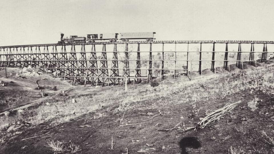 A locomotive crosses a railway bridge during the construction of the Transcontinental Railway in America. (Photo by Otto Herschan Collection/Hulton Archive/Getty Images)