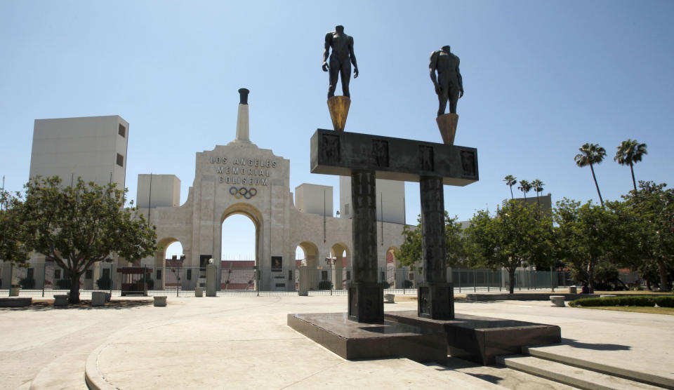 FILE - This July 1, 2009, file photo, shows the Los Angeles Memorial Coliseum with a pair of athlete statues installed for the 1984 Olympics, foreground, in Los Angeles. The University of Southern California's sale of naming rights for Los Angeles Memorial Coliseum is being criticized as dishonoring the historic stadium's dedication as a memorial to soldiers who fought and died in World War I. USC announced last year that the stadium will be renamed United Airlines Memorial Coliseum as part of a $270 million renovation of the facility, which opened in 1923. (AP Photo/Charlie Riedel)