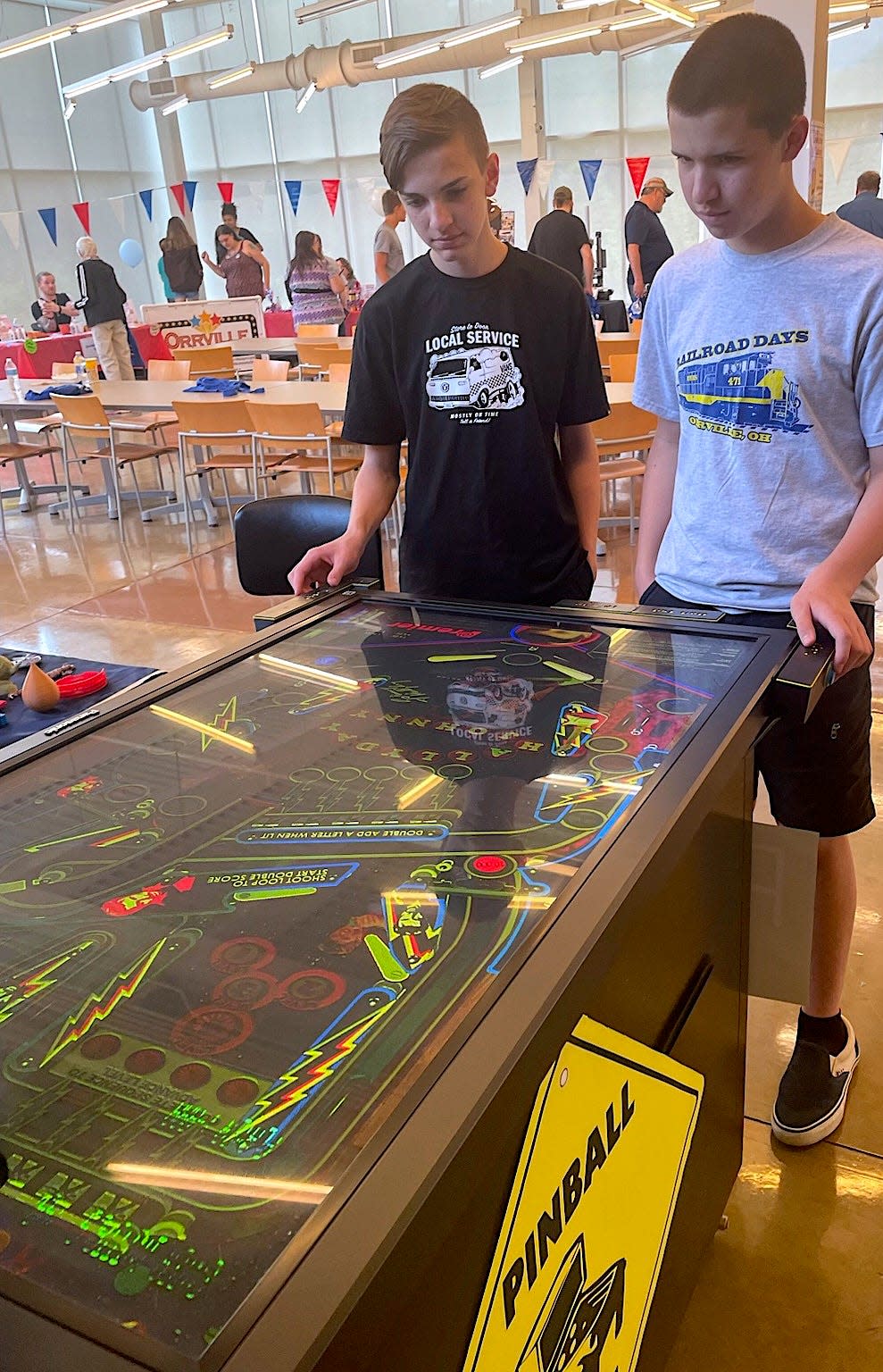 Alex (left) and Ethan Williams play an LED monitor pinball machine at the Wayne County Makers Faire at Wayne College in 2021.