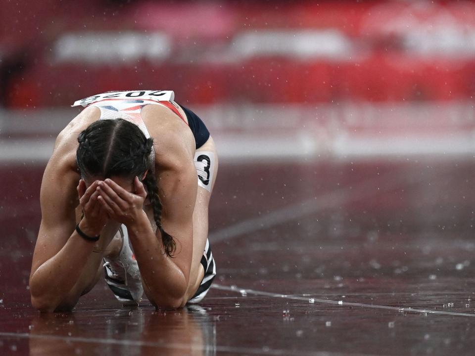 Britain's Jessica Turner sits on her hands and knees on the track in the rain at the Tokyo Olympics