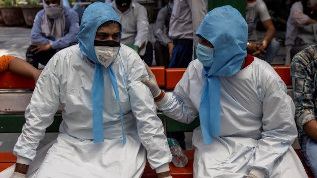 A man is consoled by his brother after their father died due to the coronavirus disease (COVID-19), at a crematorium ground in New Delhi, India, April 28, 2021.