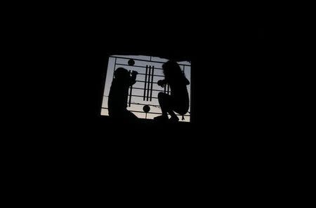 Palestinian children look out of the window of their family house during a power cut in Khan Younis, in the southern Gaza Strip, July 3, 2017. REUTERS/Mohammed Salem