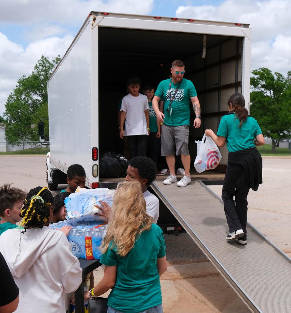 Blake Mackey directs students Friday as they load the truck with supplies.