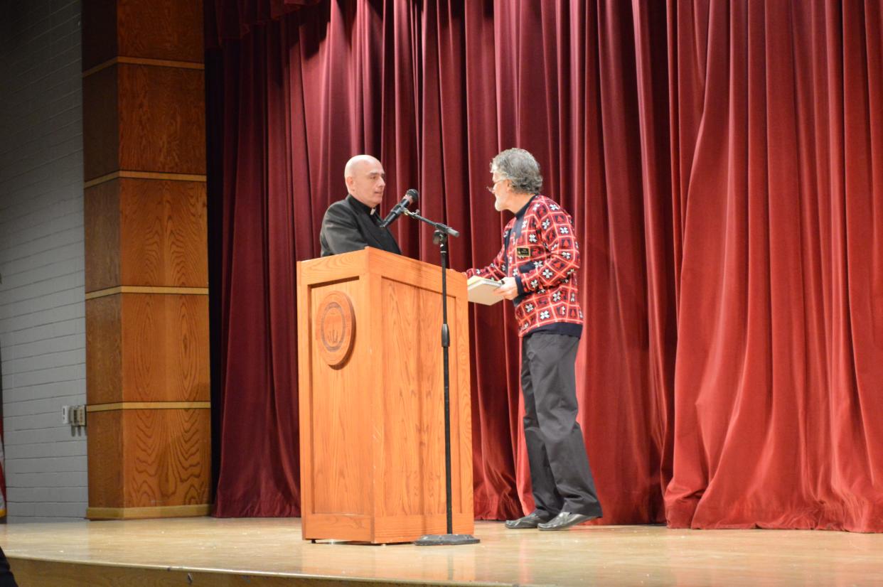 The Rev. Christopher Scott Fronk is greeted by Tom Haag, chairman of the Walsh Jesuit board of directors. Fronk will become the 12th president of Walsh Jesuit High School in Cuyahoga Falls in July.