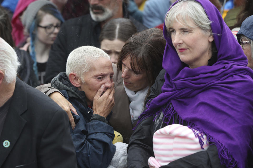 People gather to protest at the site of the former Tuam home for unmarried mothers in County Galway, during the visit to Ireland by Pope Francis, Sunday, Aug. 26, 2018. Survivors of one of Ireland's wretched mother and baby homes were to hold their own demonstration Sunday. The location is Tuam, site of a mass grave of hundreds of babies who died at a church-run home. (Niall Carson/PA via AP)