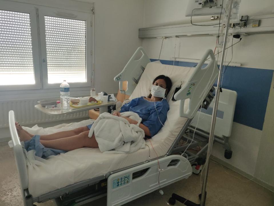 Pictured is Intan Clement lying in her hospital bed wearing a surgical mask after contracting coronavirus. 