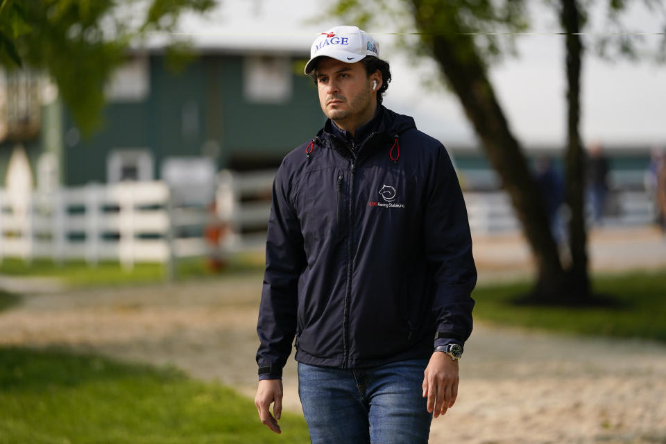 Assistant trainer Gustavo Delgado Jr. walks to the track to watch his horse Mage work out ahead of the 148th running of the Preakness Stakes horse race at Pimlico Race Course, Wednesday, May 17, 2023, in Baltimore. (AP Photo/Julio Cortez)