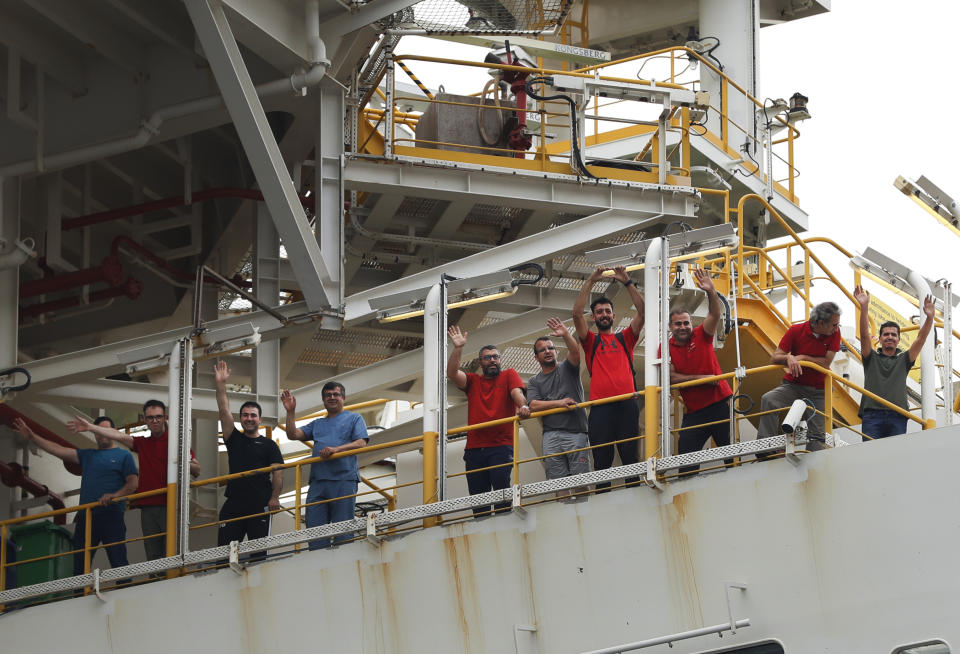 Crew members of Turkey's 230-meter (750-foot) drillship 'Yavuz' wave as the ship leaves the port of Dilovasi, outside Istanbul, on its way to the Mediterranean, Thursday, June 20, 2019. Turkey has launched Yavuz, a second drillship that will drill for gas off neighboring Cyprus' east coast despite European Union warnings to refrain from such illegal actions or face sanctions.(AP Photo/Lefteris Pitarakis)