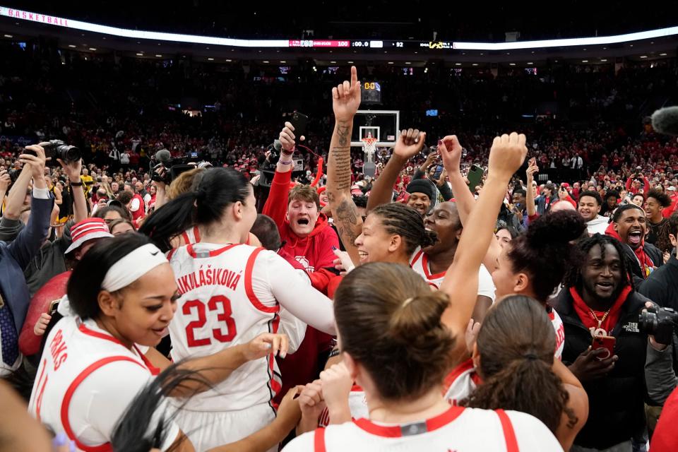 As fans rush the court, Ohio State players celebrate after defeating Iowa in January.