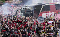 The team bus of Bayer Leverkusen is welcomed by thousands of supporters at the stadium ahead of the German Bundesliga soccer match between Bayer Leverkusen and Werder Bremen in Leverkusen, Germany, Sunday, April 14, 2024. Leverkusen could win the Bundesliga title if they win the match against Bremen.(AP Photo/Martin Meissner)