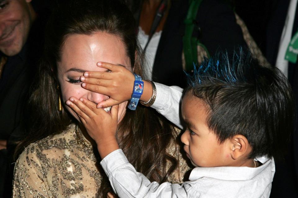 <p>Playing peekaboo with son Maddox at the <em>Shark Tale</em> premiere in September 2004.</p>