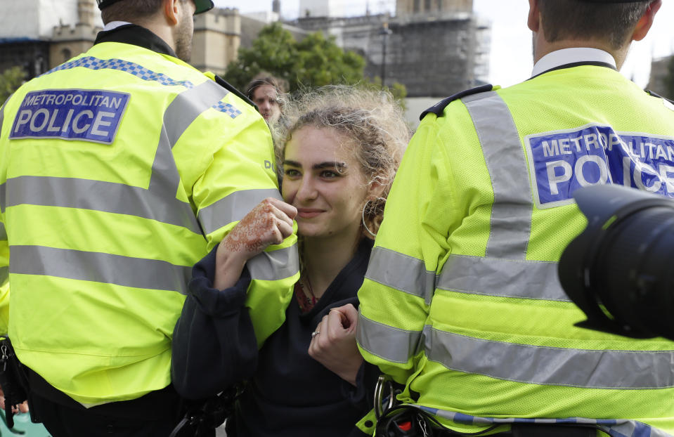 Police arrest a climate demonstrator on Whitehall in London, Tuesday, Oct. 8, 2019. Police are reporting they have arrested more than 300 people at the start of two weeks of protests as the Extinction Rebellion group attempts to draw attention to global warming. (AP Photo/Kirsty Wigglesworth)