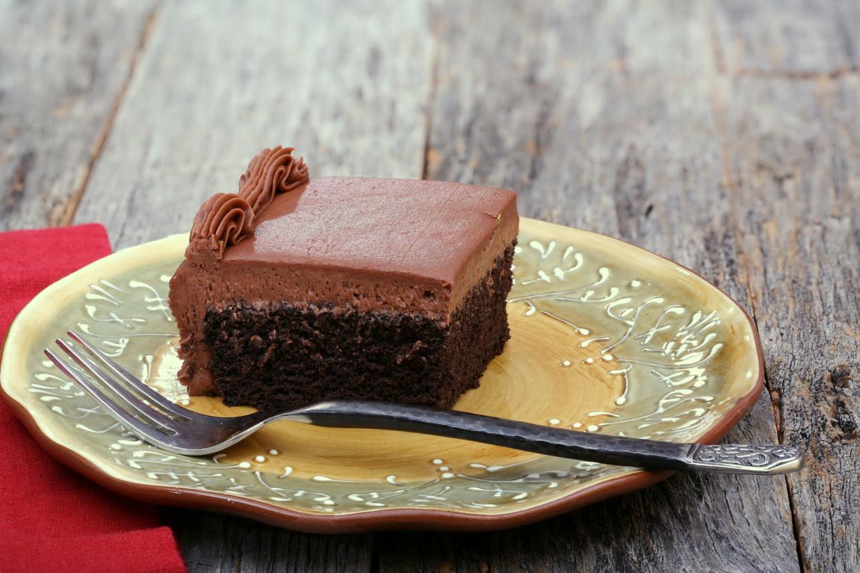 Chocolate sheet cake covered with chocolate icing on a plate with a fork