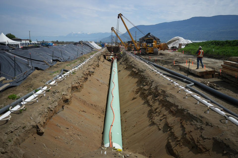 Workers lay pipe during construction of the Trans Mountain pipeline expansion on farmland, in Abbotsford, B.C., on Wednesday, May 3, 2023. The company building the Trans Mountain pipeline expansion has been cited for environmental non-compliance related to its management of recent flooding in B.C. THE CANADIAN PRESS/Darryl Dyck