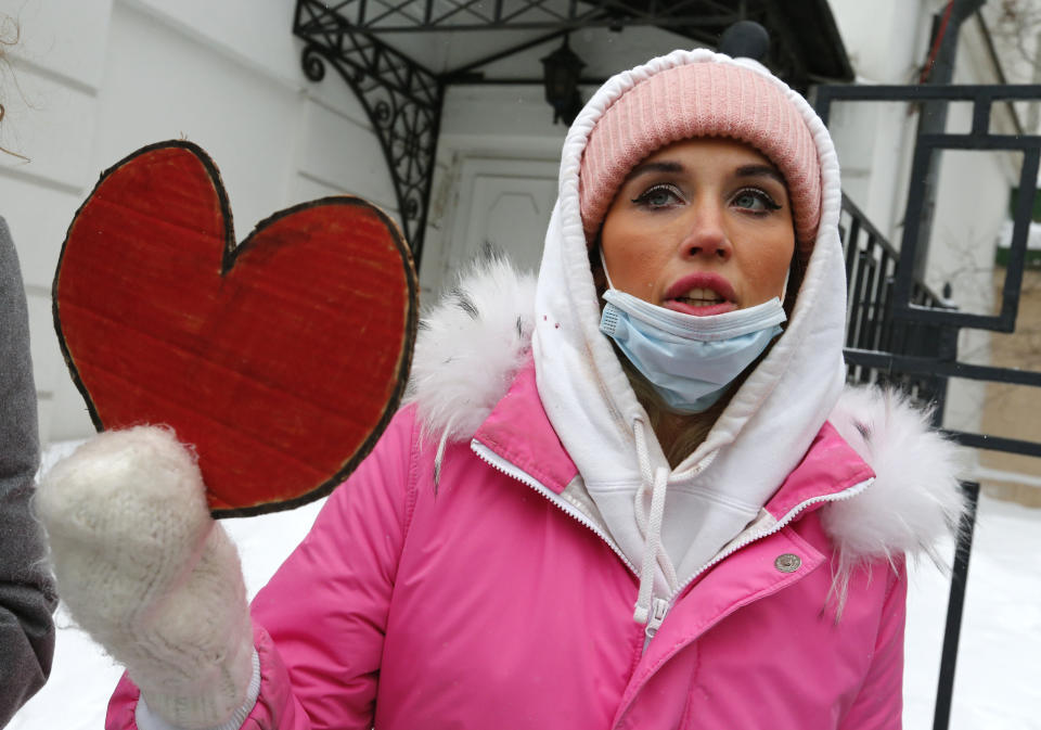 A woman, wearing face masks to protect against coronavirus, attends a rally in support of jailed opposition leader Alexei Navalny and his wife Yulia Navalnaya, in Moscow, Russia, Sunday, Feb. 14, 2021. (AP Photo/Alexander Zemlianichenko)