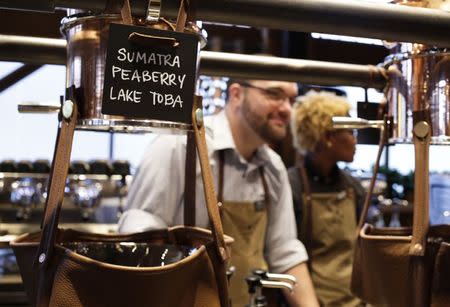 A Starbucks barista looks on from behind the counter, where the company will feature its small-lot coffee, during a preview of its new Reserve Roastery and Tasting Room in Seattle, Washington December 4, 2014. REUTERS/Jason Redmond