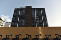 A mural depicting oil wells is seen in front of an abandoned building in downtown Midland